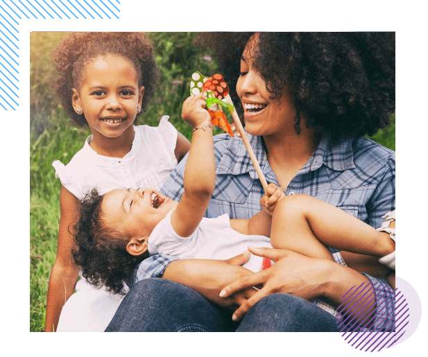 A woman holding a child and another girl.